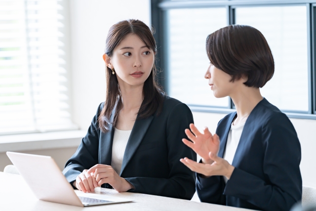 未経験から特許事務を目指す方が先輩社員から業務の説明を受けながら専門知識や実務について学んでいるイメージ